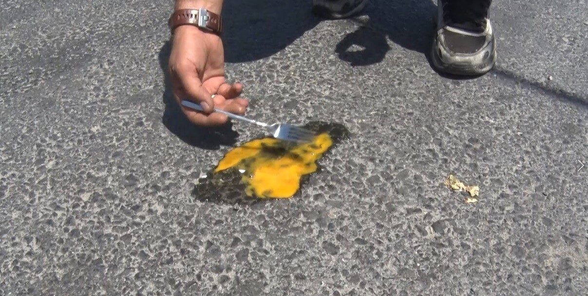 İstanbul’da hava sıcaklıklarının artmasının ardından bir esnaf, asfaltta sıcaklığı göstermek