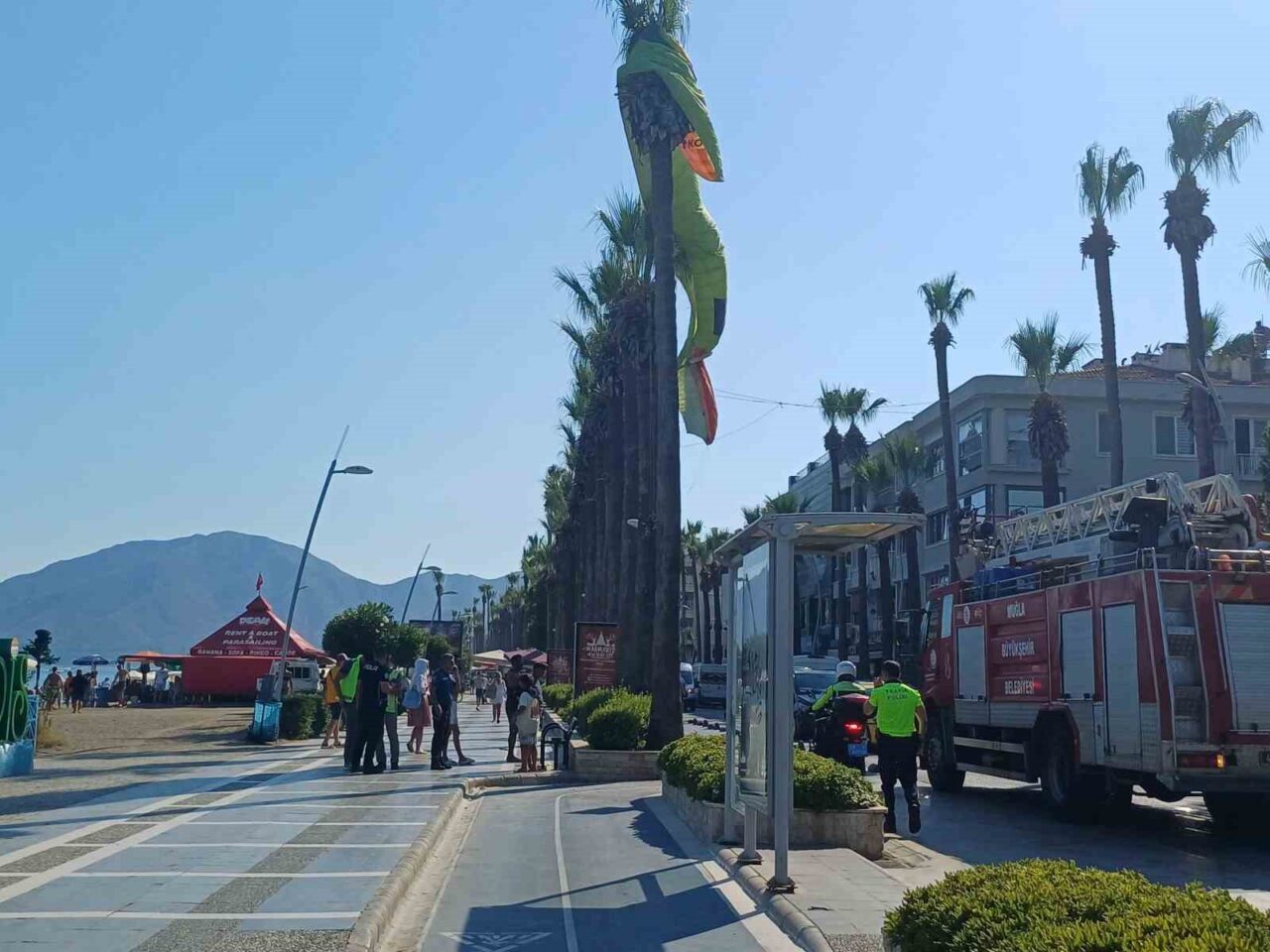 Muğla’nın Marmaris ilçesinde deniz paraşütü palmiye ağacına takılırken, ağaçta asılı