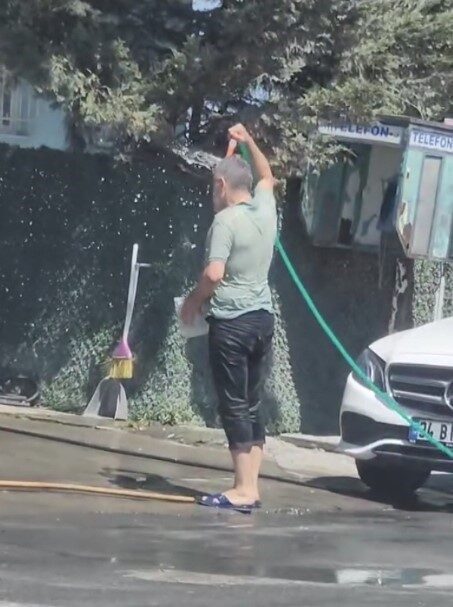 Sultangazi’de sıcaktan bunalan bir vatandaş hortumla hem kendini hem de