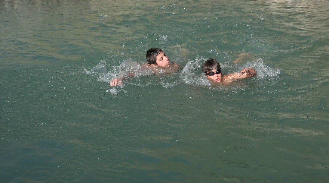 Erzincan’ın Üzümlü ilçesinde sıcak havadan bunalan çocuklar, derede suya girerek