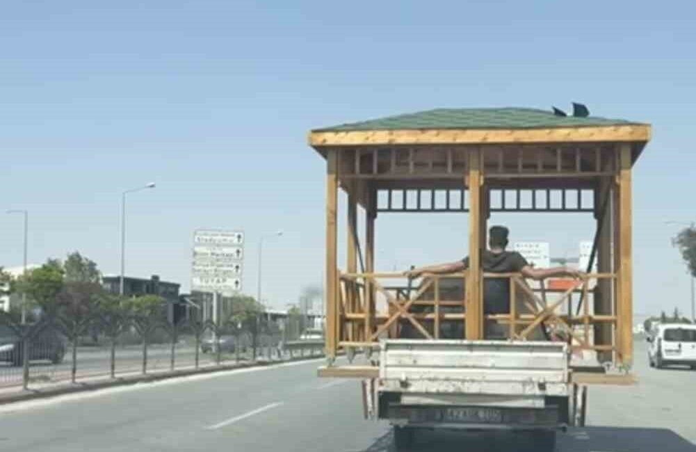 Konya’da trafikte seyreden bir kamyonetin kasasında taşınan kamelyada oturan vatandaş,