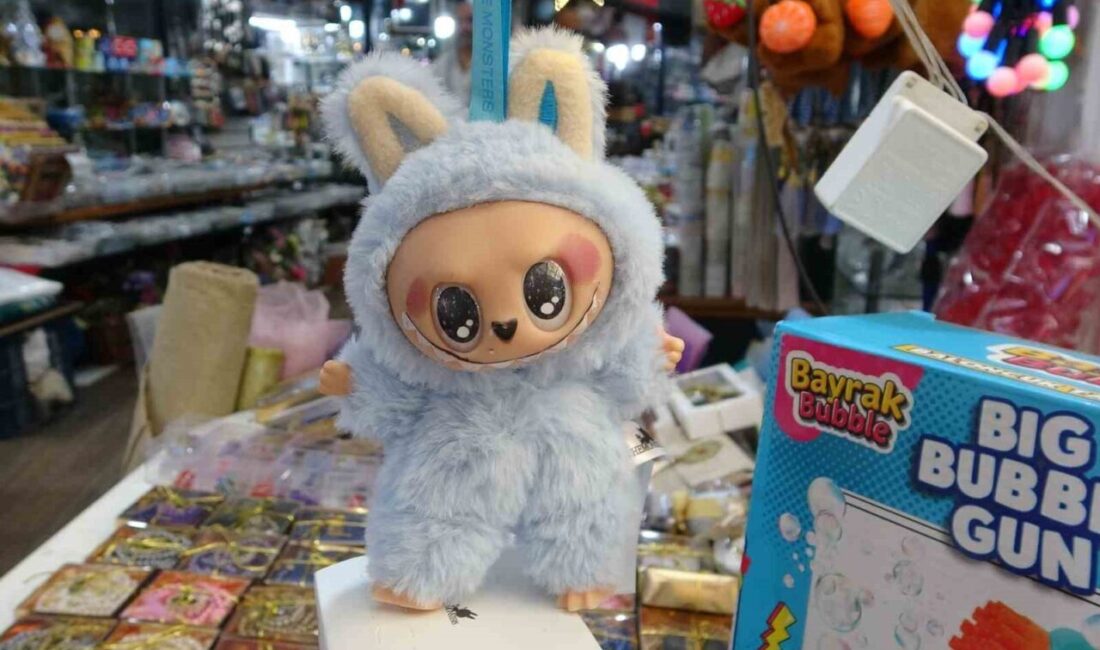 Mersin’de yanında bir yetişkinle birlikte oyuncakçının önünden geçen kız çocuğu,