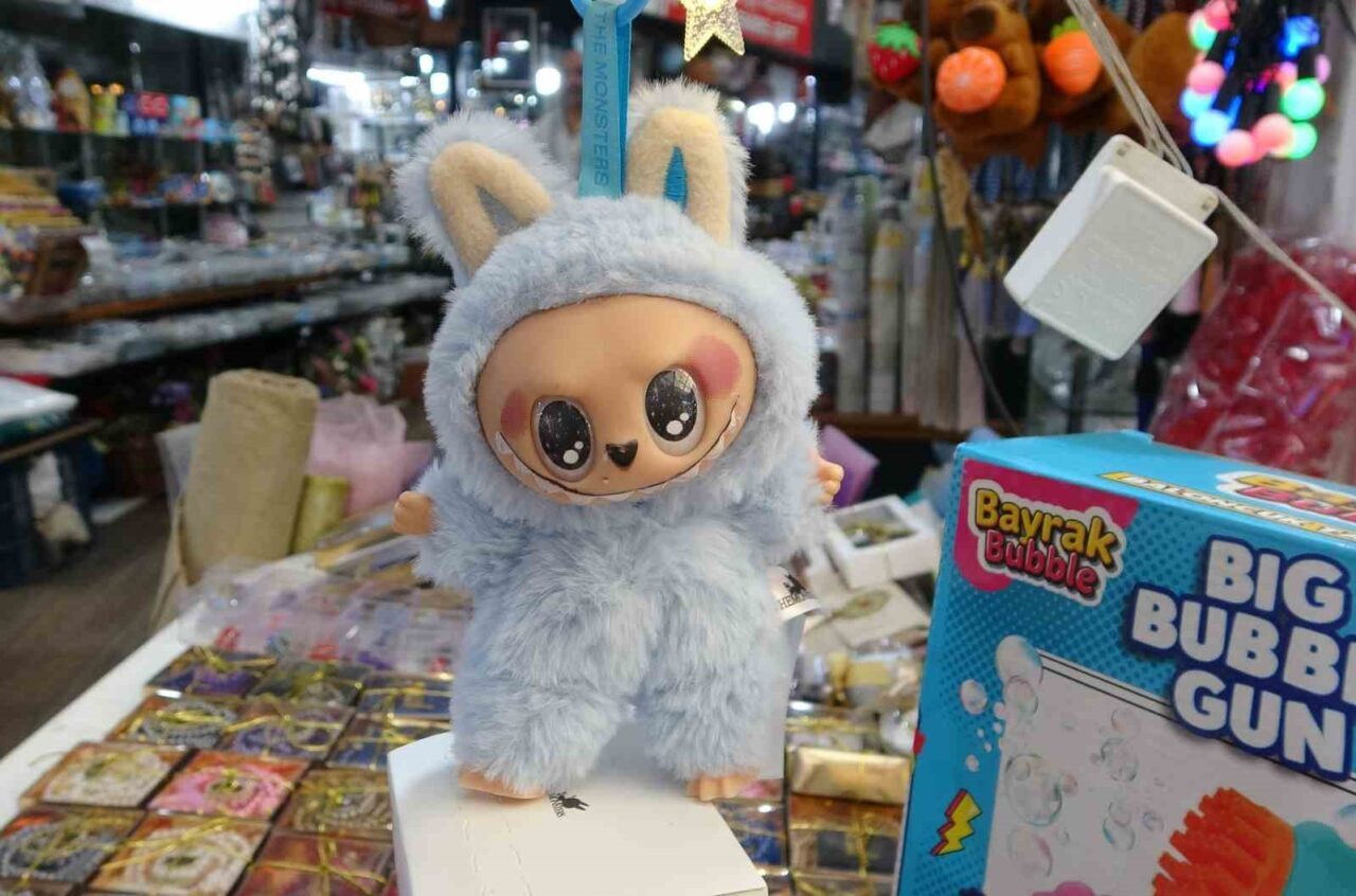 Mersin’de yanında bir yetişkinle birlikte oyuncakçının önünden geçen kız çocuğu,