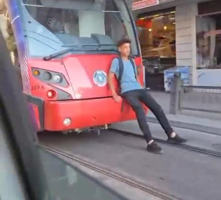 Bursa’da, seyir halindeki tramvayın arkasına oturarak yolculuk yapan bir çocuk
