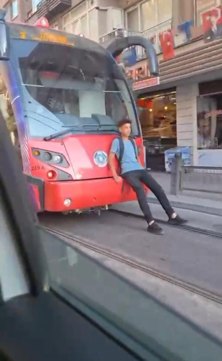 Bursa’da, seyir halindeki tramvayın arkasına oturarak yolculuk yapan bir çocuk