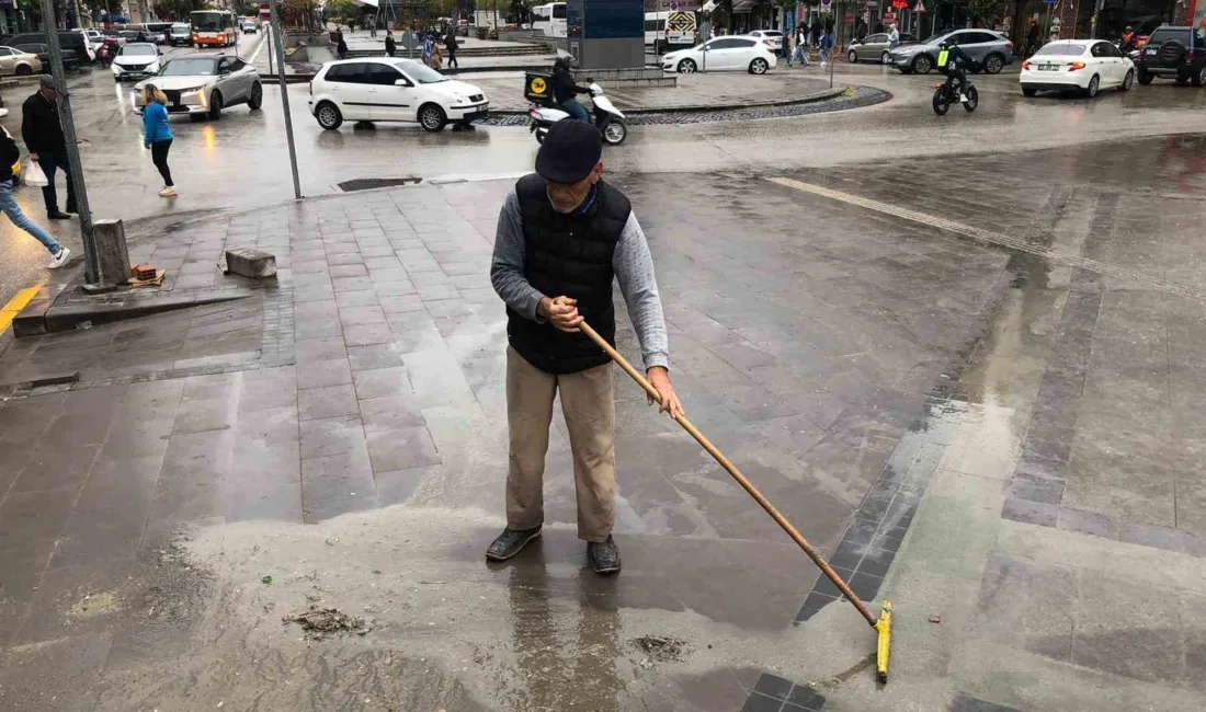 Eskişehir’de bir vatandaş, caddede yağmur sonrasında oluşan çamuru temizleyerek örnek