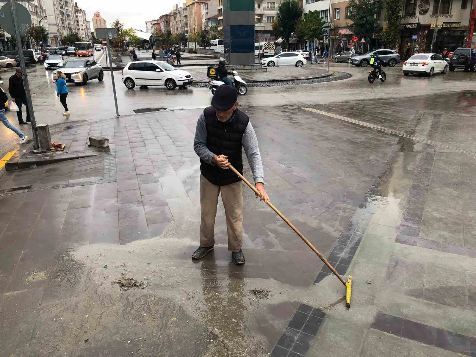 Eskişehir’de bir vatandaş, caddede yağmur sonrasında oluşan çamuru temizleyerek örnek