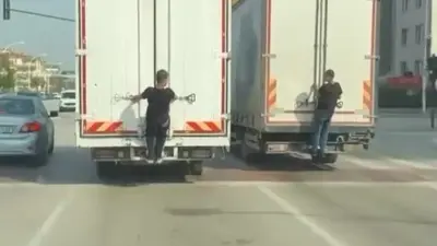 Bursa’da seyir halindeki kamyonların arkasına tutunarak yolculuk yapan gençler, hem