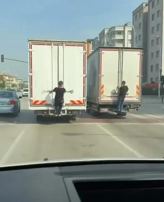 Bursa’da seyir halindeki kamyonların arkasına tutunarak yolculuk yapan gençler, hem